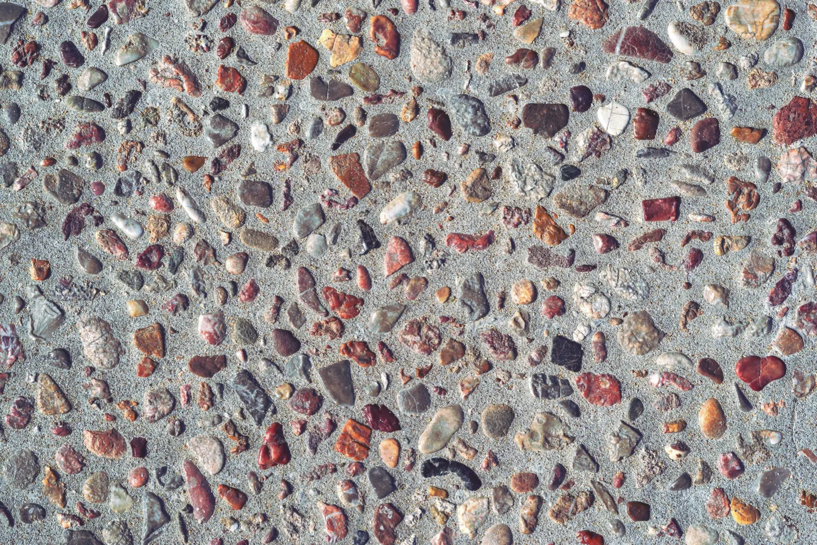 Close-up of exposed aggregate concrete with a red and terracotta stone blend